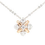 A two-tone 14k gold necklace with a loose rope chain and multiple earth mined diamonds set in a central pendant.