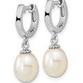 A pair of silver huggie hoop earrings with dangling freshwater pearls, shown on a plain white background.
