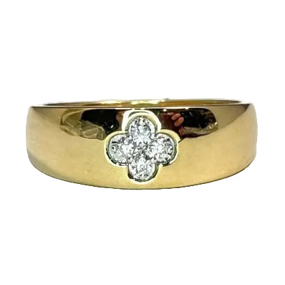 A gold cigar band ring with a clover-shaped diamond setting on the top.