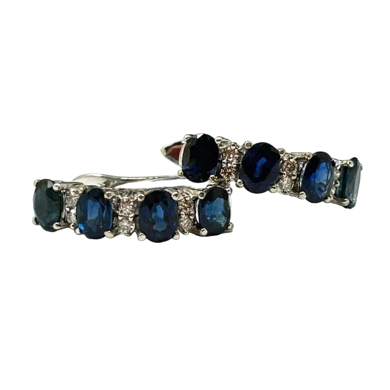A pair of hoop earrings featuring alternating diamonds and sapphires set in 18K white gold.
